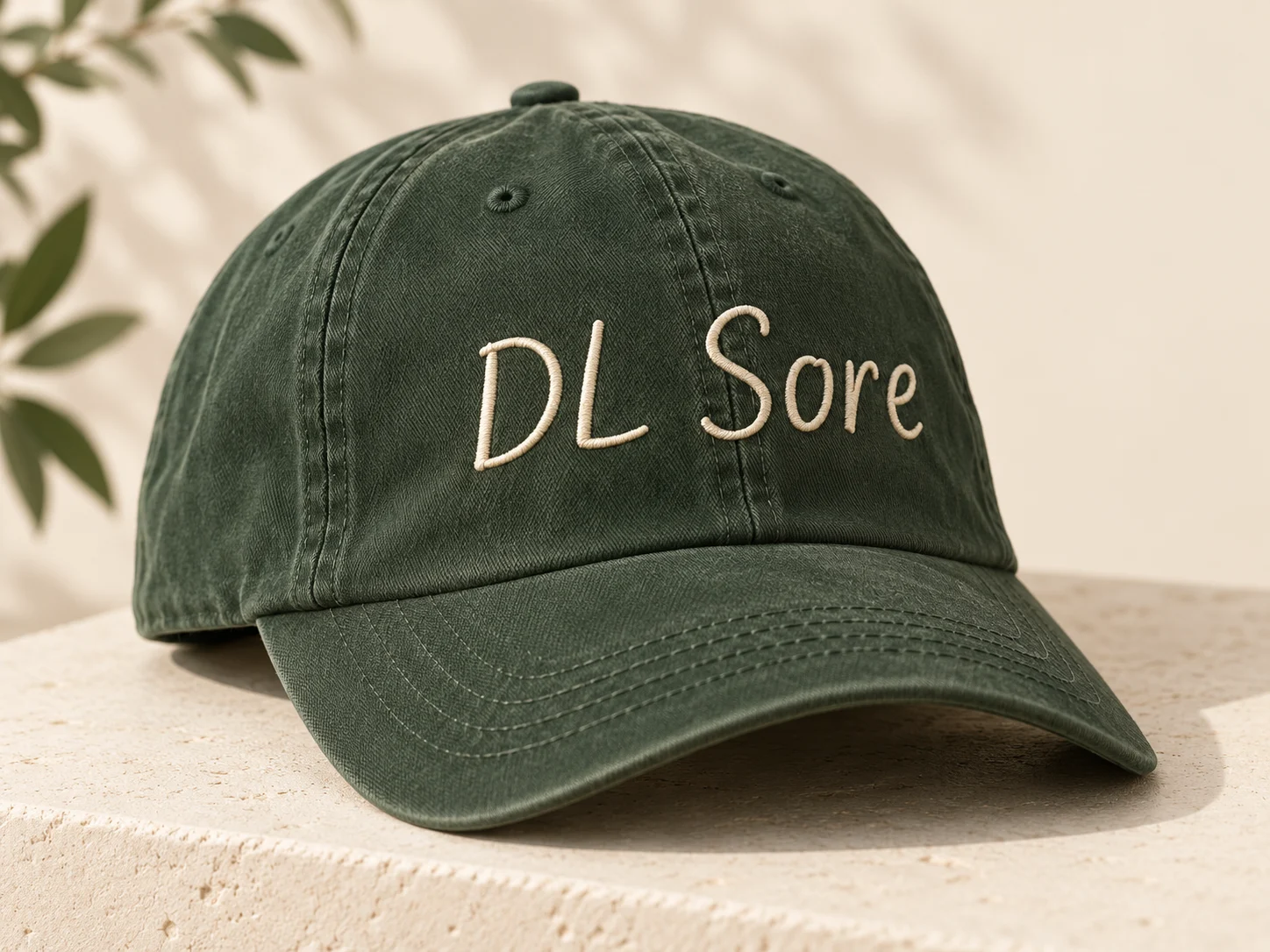Generated concept: Forest-green cotton cap with ivory DL Sore embroidery.