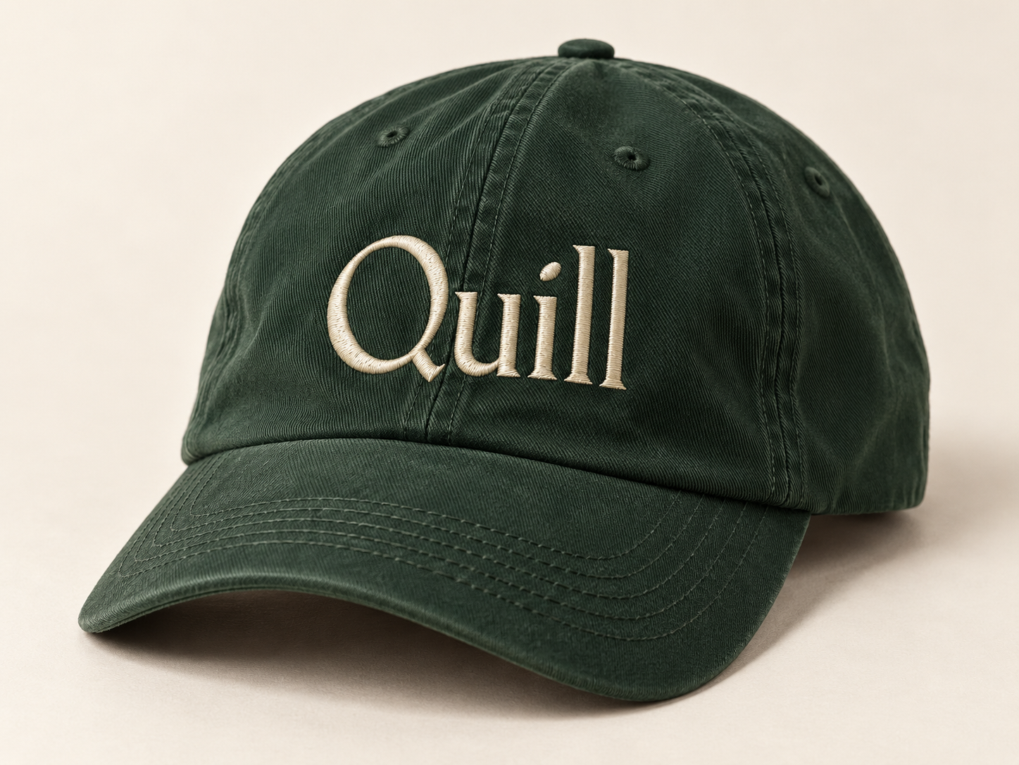 Generated concept of a forest-green cotton cap with cream Quill embroidery on a warm neutral surface.