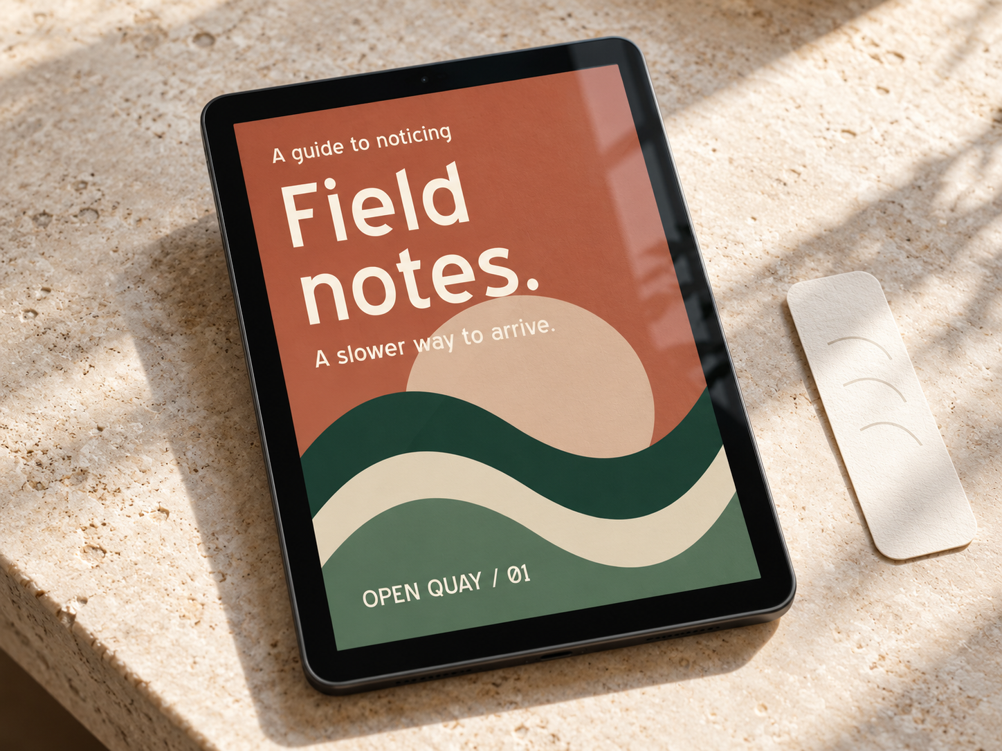 Generated photographic-style concept of a tablet displaying a terracotta and green Field notes ebook cover on a stone surface.